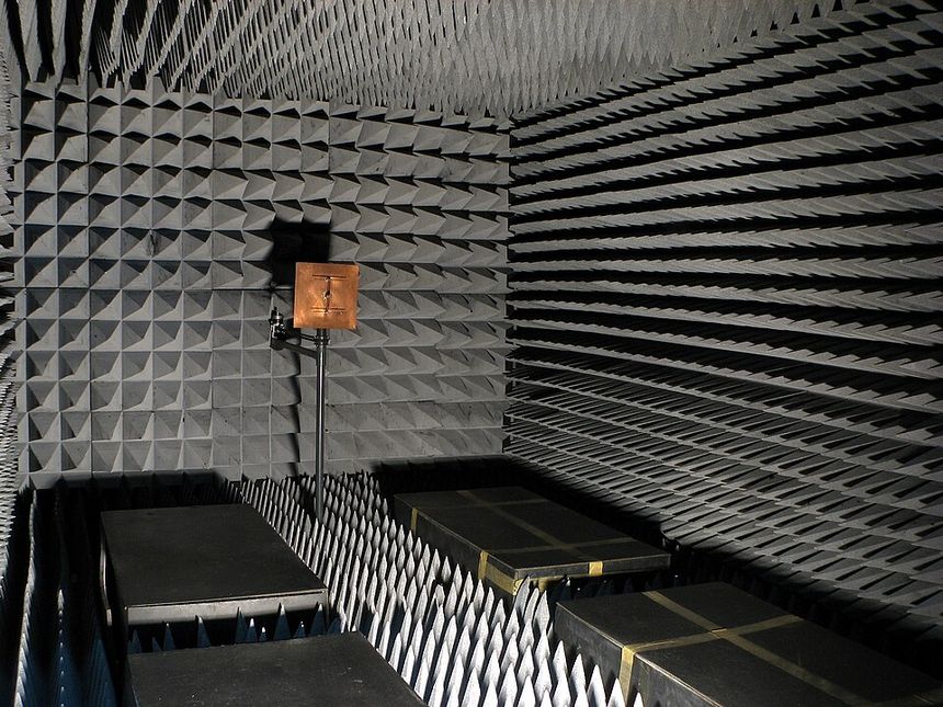 A radio-frequency anechoic chamber: every surface covered in grey foam cones, designed so nothing reflects and nothing escapes.